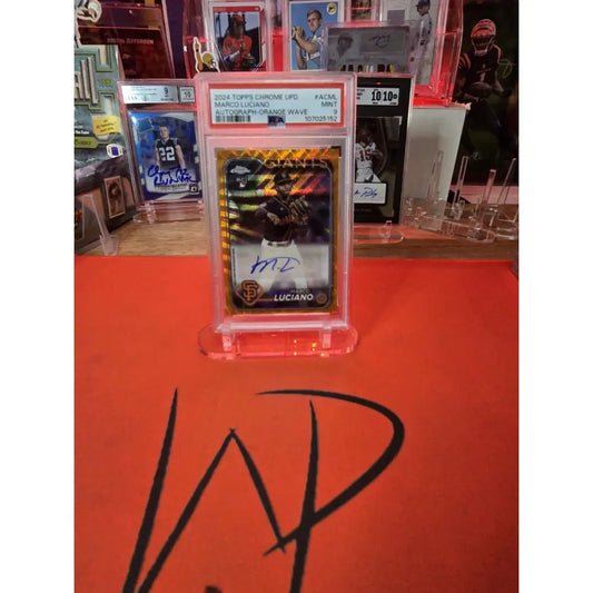 Graded Marco Luciano autographed baseball card with an orange wave design.