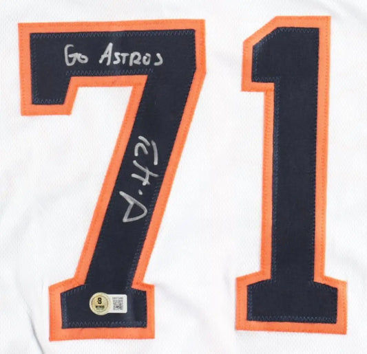 White sports jersey with ’71’’ in black and orange trim, featuring an autograph and ’Go Astros’.